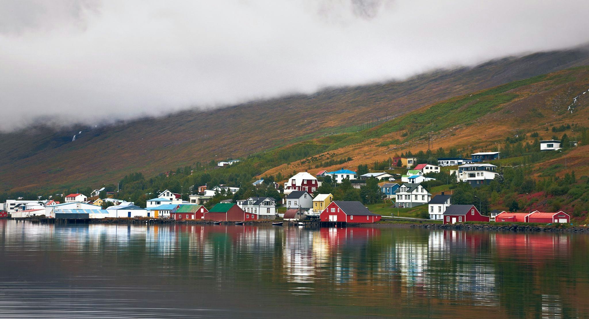 waterfront village with colorful houses reflected in the calm water 