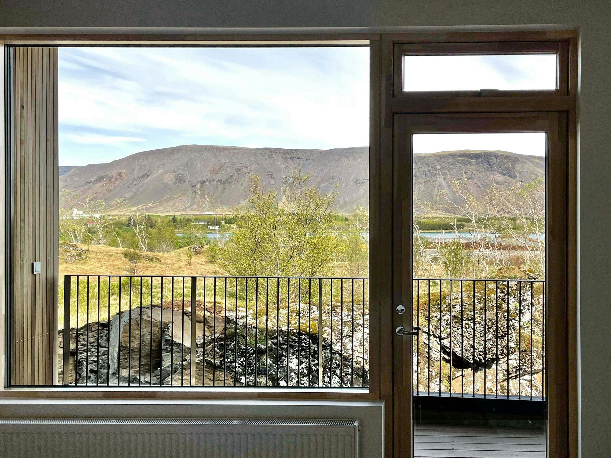 A scenic view of a mountainous landscape seen through a large window 