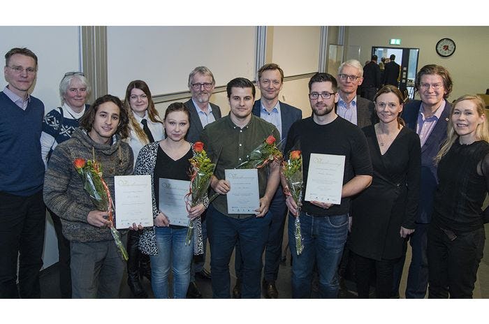 A group of people standing together, holding flowers and certificate