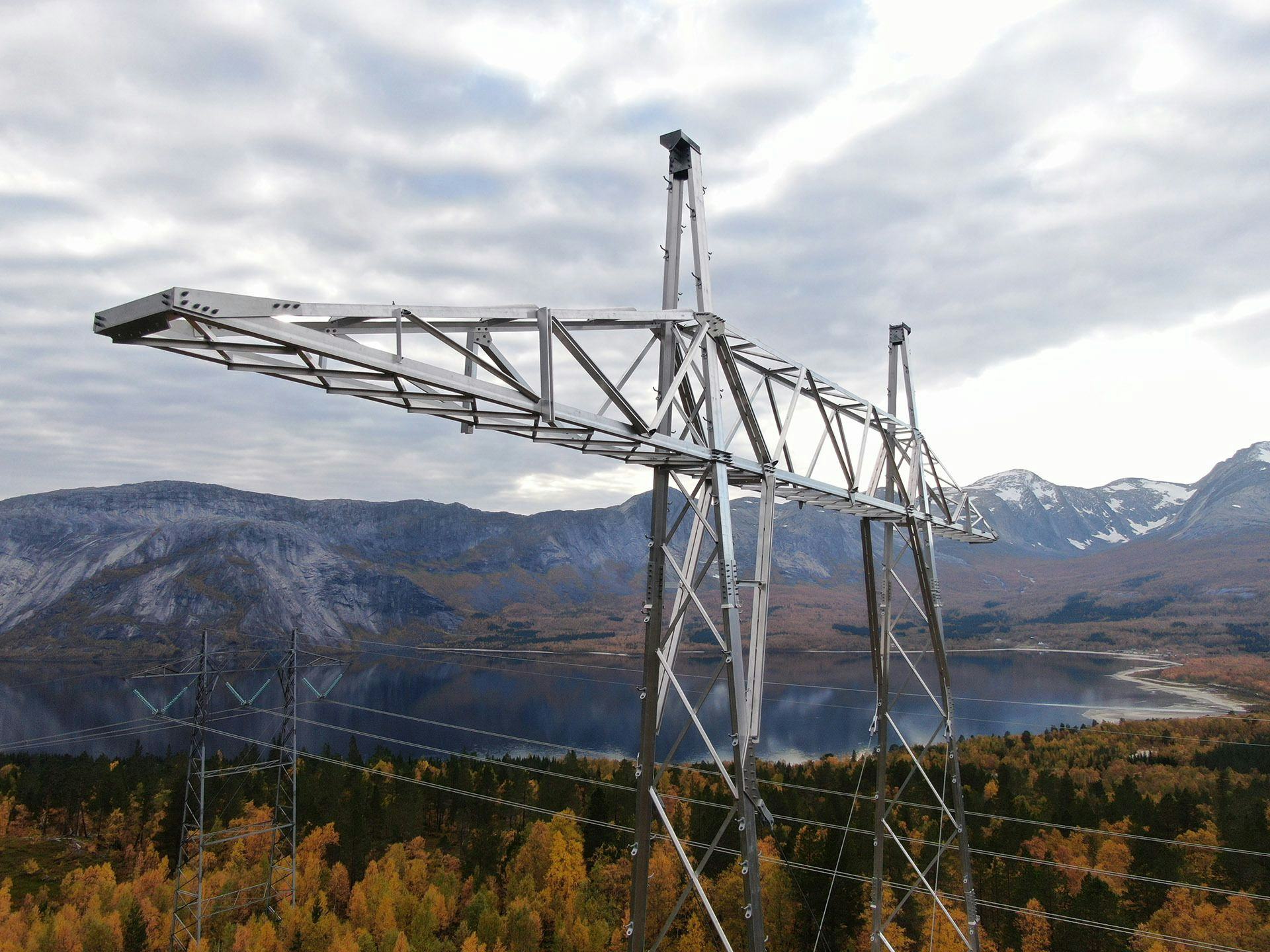 A large electricity pylon with mountainous landscape in the background