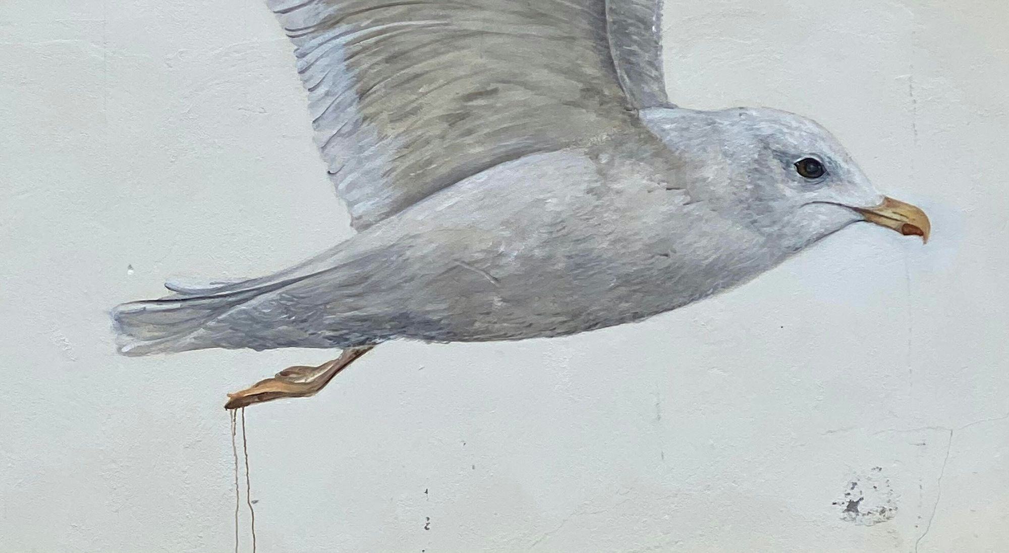 A close up of a painted seagull in flight