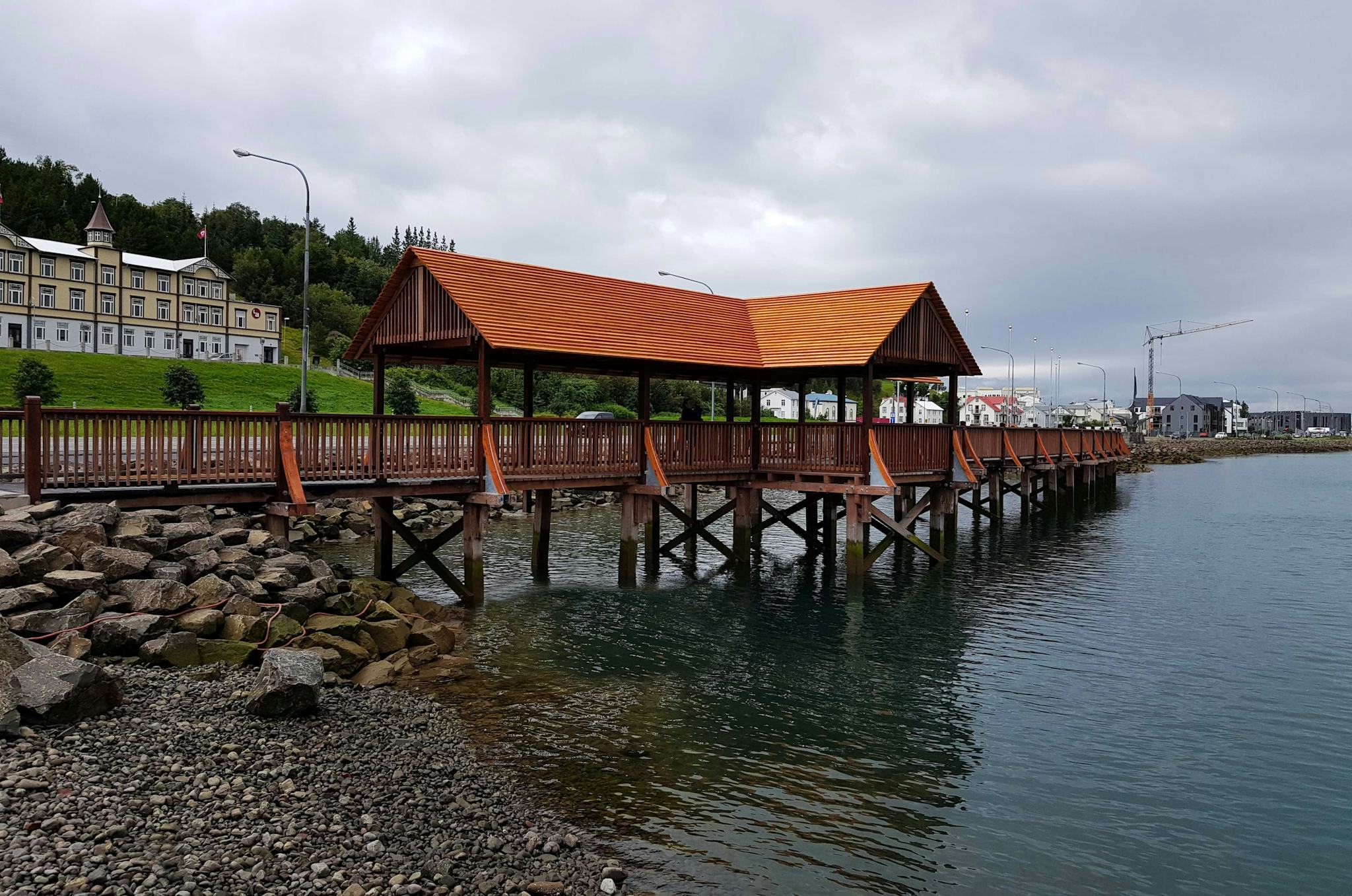 Wooden pedestrian bridge with distinctive roof by the water