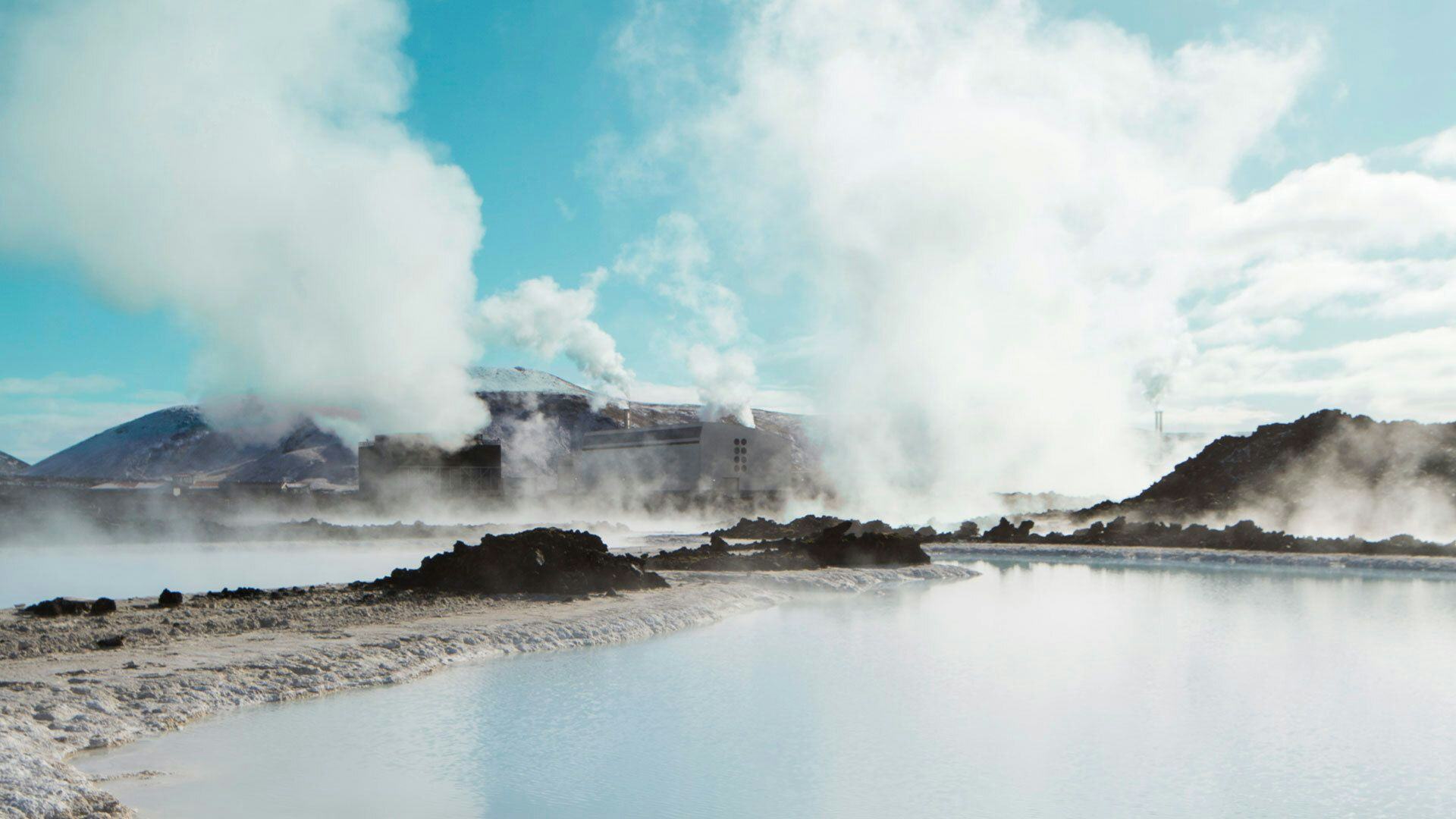 A geothermal area with steam rising from the ground