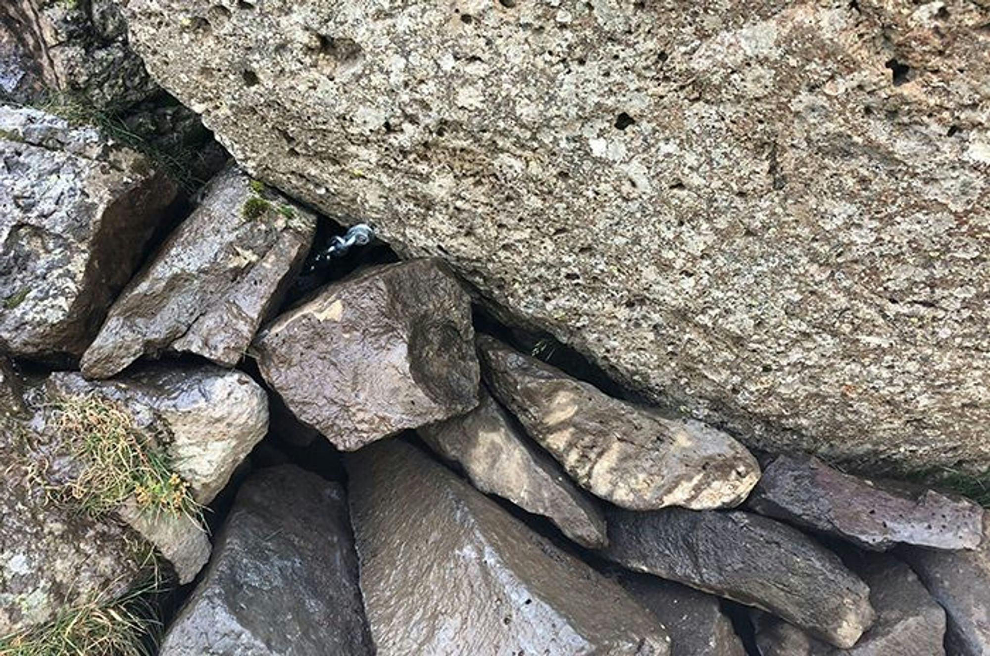Close up view of a large rock supported by small stones