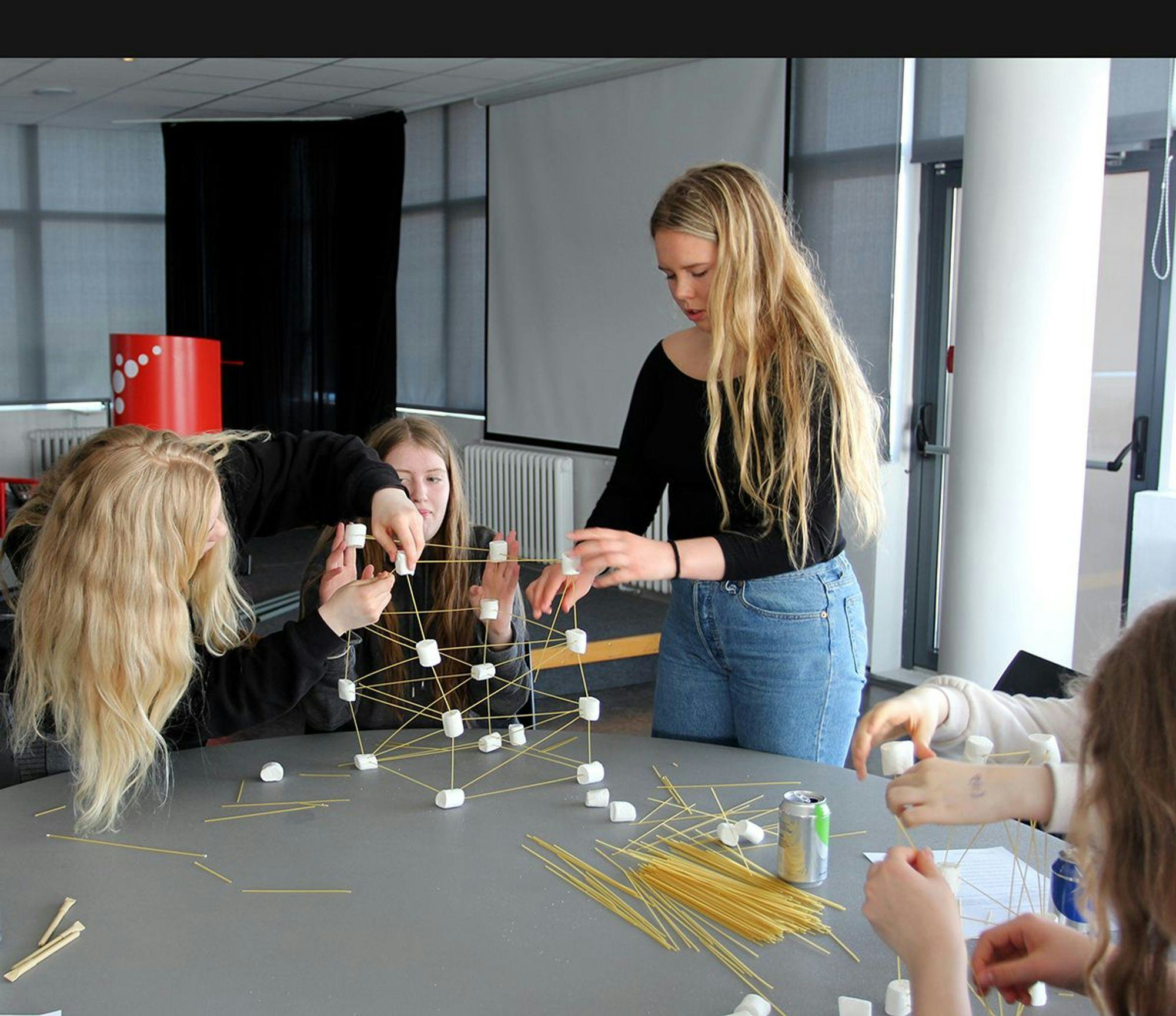 Three girls making a prototype using marshmallow and spaghettis 