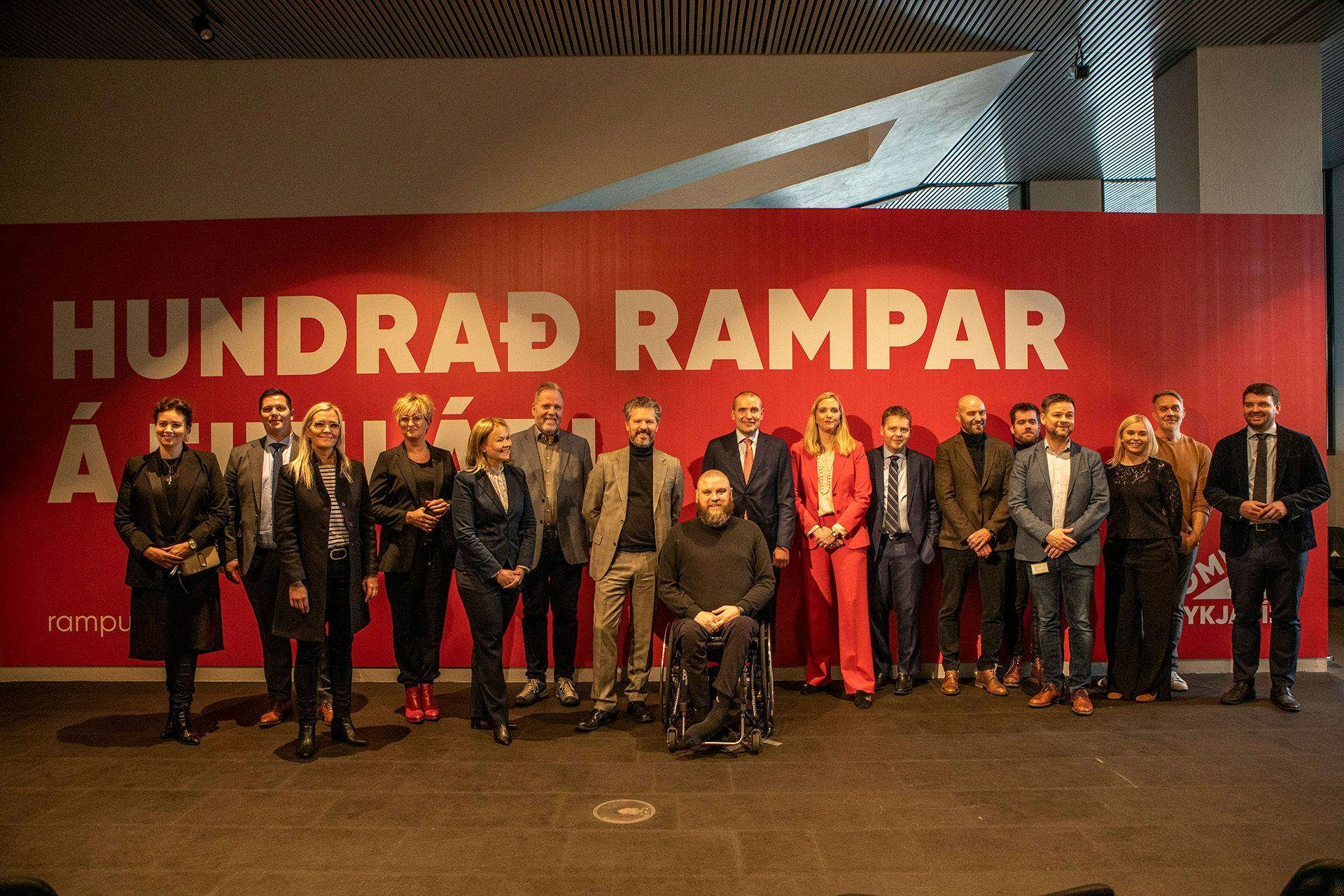 A group of people standing together in front of a red banner that reads "HUNDRAD RAMPAR"