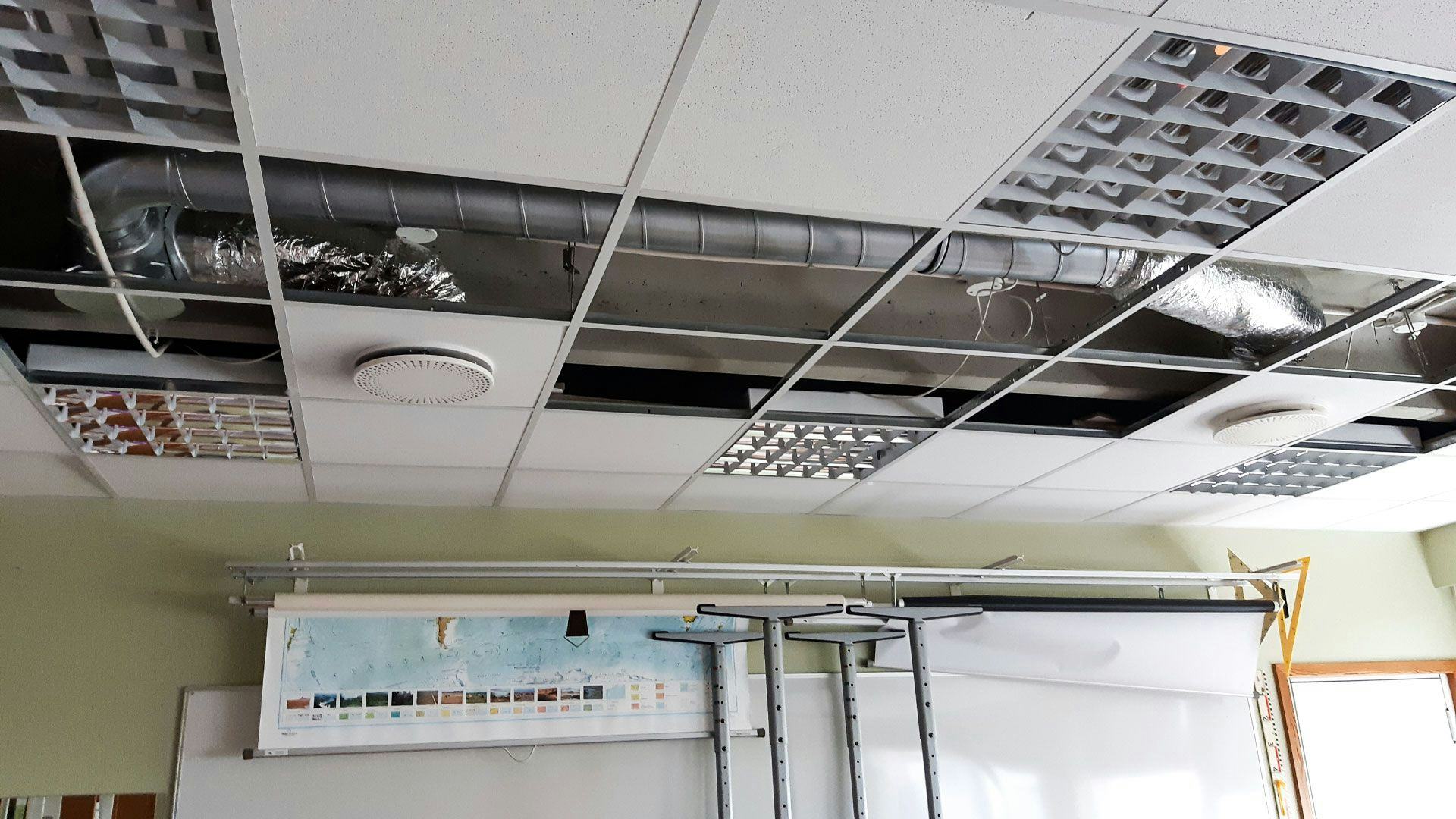 A room with a partially exposed ceiling revealing ductwork