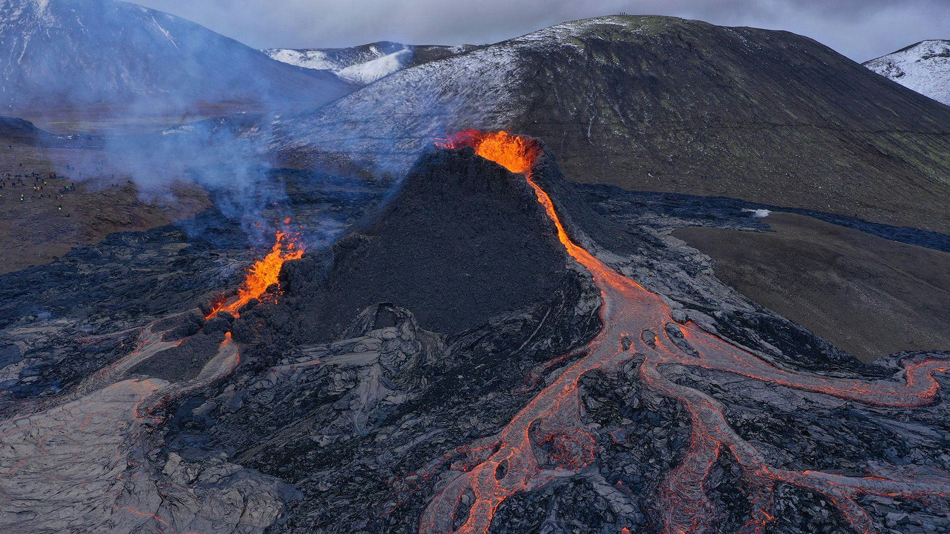 An active volcano eruption with lava flowing down the terrain, emitting smoke