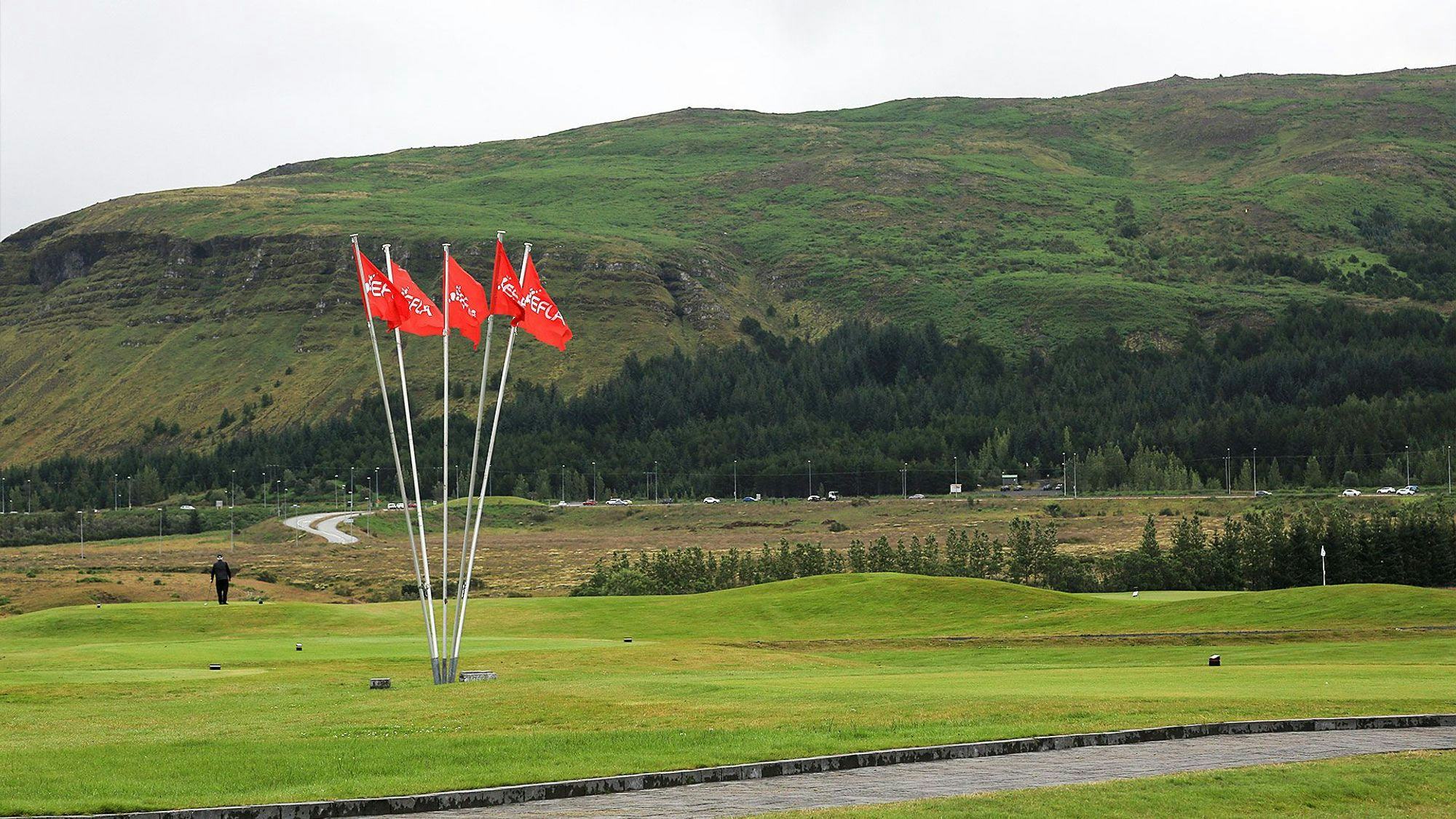 Few red flags fluttering in the middle of a golf course