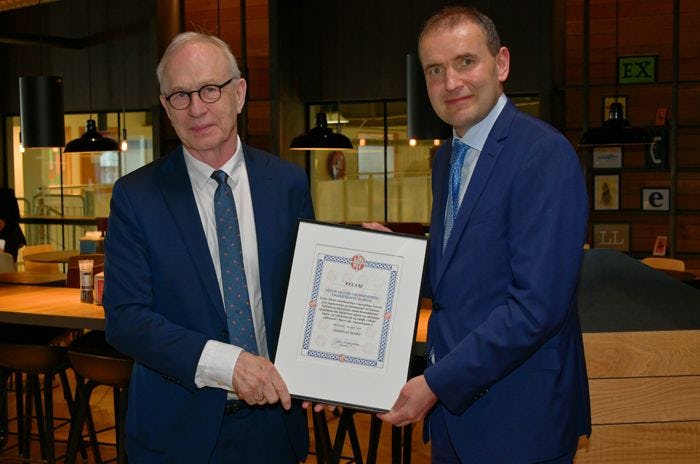 Two men holding a framed certification together