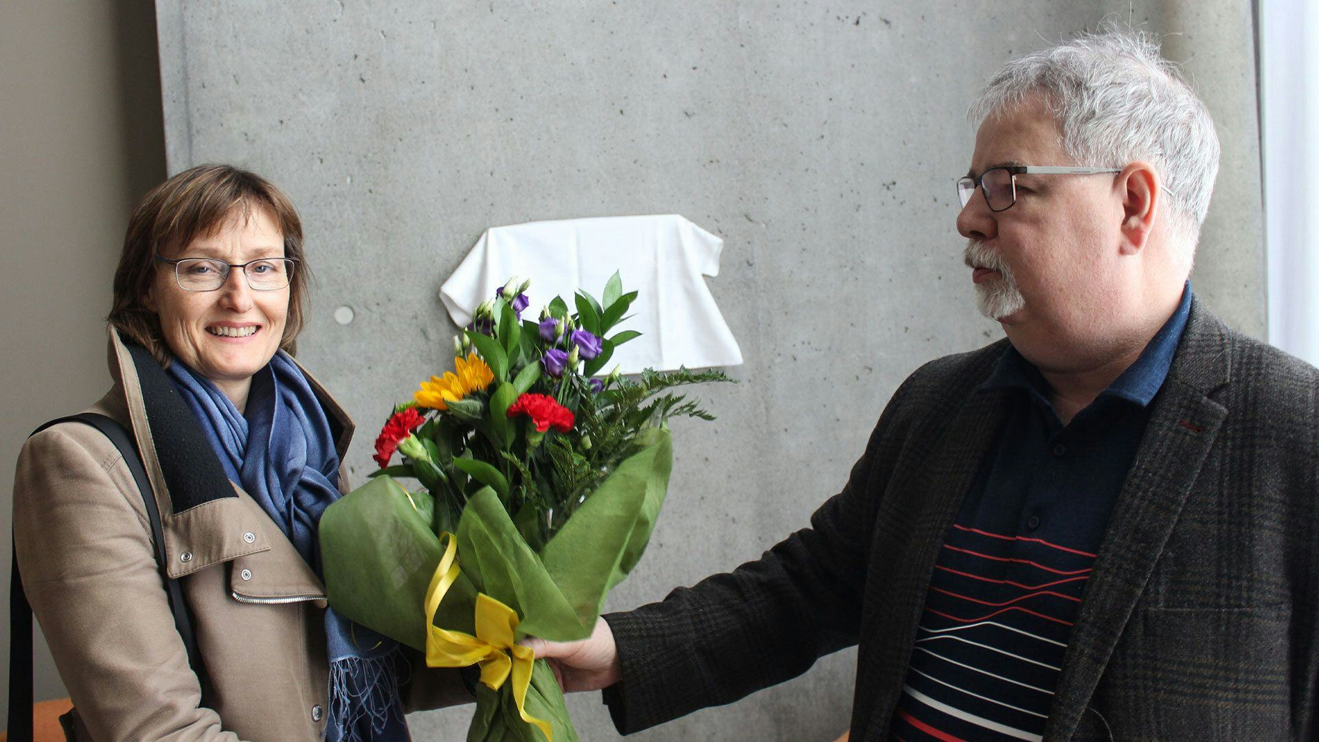 A man is handing over a bouquet of flowers to a women 