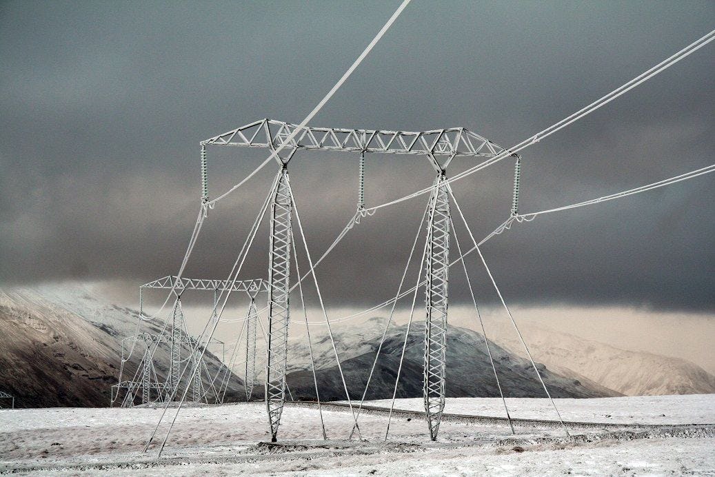 Electrical transmission towers against a mountainous backdrop